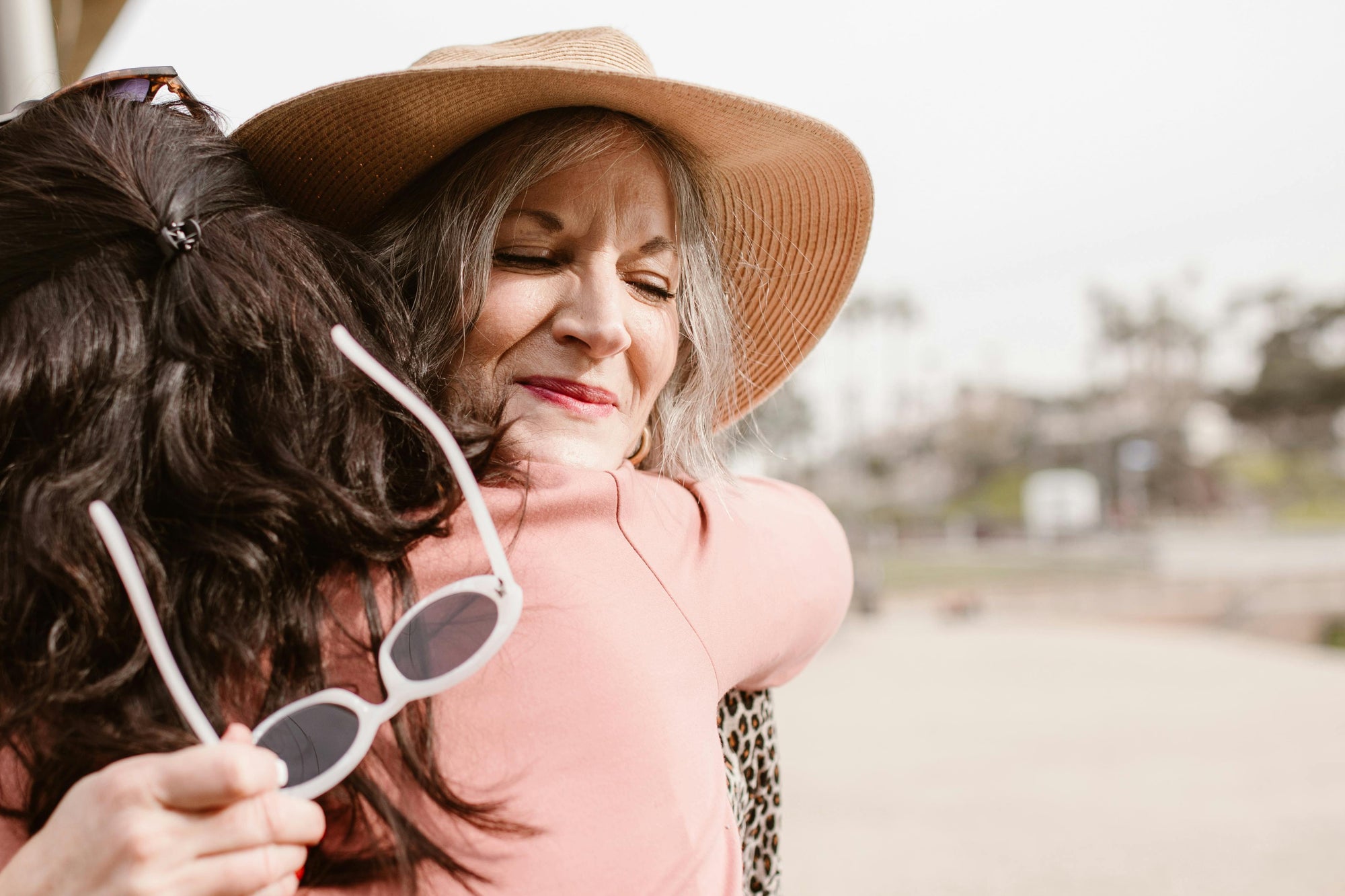 Two women hugging outdoors, thanks for the gift!